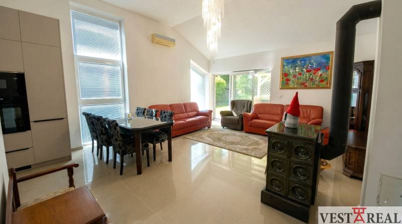 Obývacia izba v rodinnom dome s koženými sedačkami, stolom a keramickou pecou..jpg