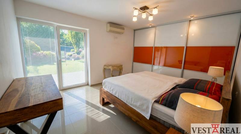 Spálňa v rodinnom dome s dreveným nábytkom a šatníkovou skriňou.jpg