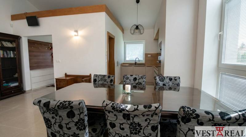 Jedáleň v rodinnom dome s veľkým stolom a vzorovanými stoličkami..jpg