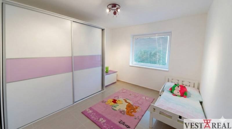 Detská izba v rodinnom dome s posteľou, skriňou a ružovým kobercom Disney..jpg