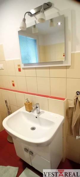Kúpeľňa s umývadlom, zrkadlom a osvetlením v 3-izbovom byte.