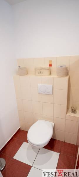 Toaleta so svetlými obkladmi v 3-izbovom byte.