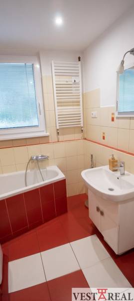 Kúpeľňa v 3-izbovom byte s vaňou, umývadlom a rebríkovým radiátorom.
